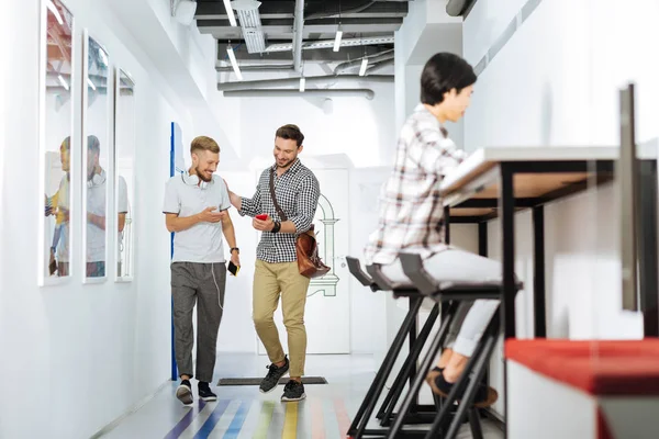 İki arkadaş bir akıllı telefon ekranına bakarak yürüyüş