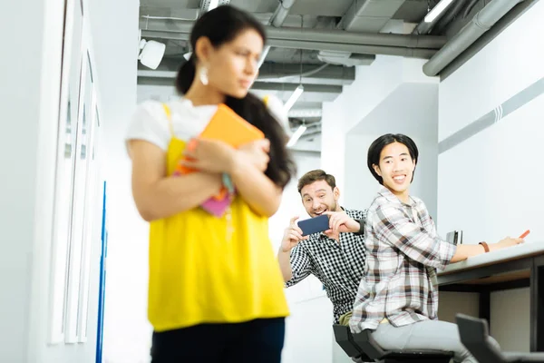 Hombres jóvenes groseros riendo y tomando fotos de chica avergonzada —  Fotos de Stock