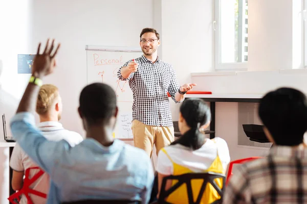 Studente alzando la mano e altoparlante allegro indicando a lui — Foto Stock