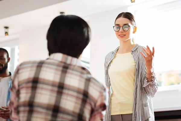 Hermosa chica sonriendo y dando inspiración a los jóvenes empresarios — Foto de Stock