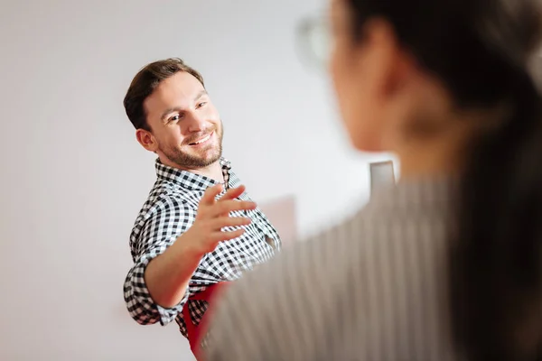 Amable hombre señalando a su colega mientras visita interesante taller — Foto de Stock