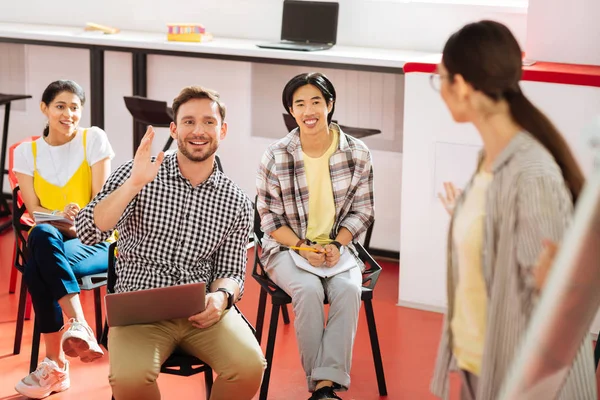 Estudiante positivo levantando la mano y dirigiéndose al maestro — Foto de Stock