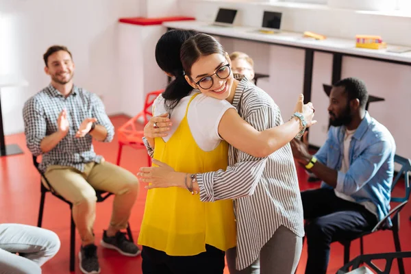 Glada kvinnor ler och kramar på psykologiska sessionen — Stockfoto