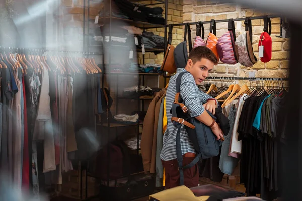 Ladrão profissional rapidamente escondendo roupas enquanto as rouba — Fotografia de Stock