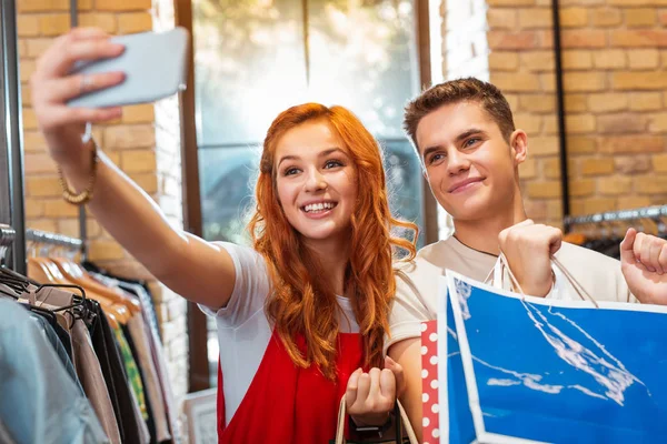 Alışveriş yaparken erkek arkadaşıyla selfie alarak güzel kadın — Stok fotoğraf
