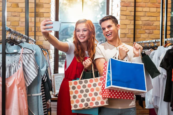 Excited couple taking selfies while doing shopping together — Stock Photo, Image