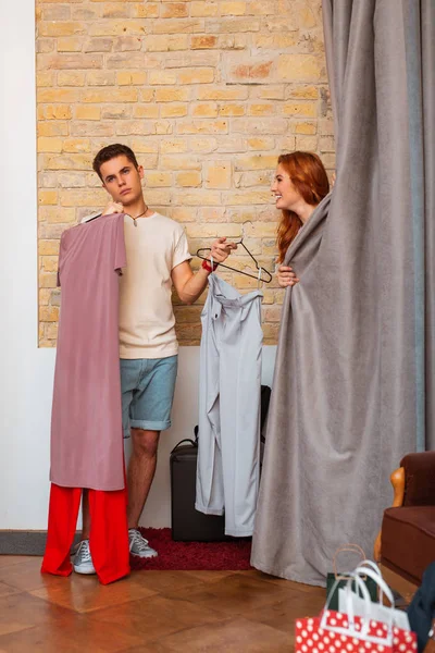 Soyunma odasına duran ve kız arkadaşı için bekleyen yorgun genç adam