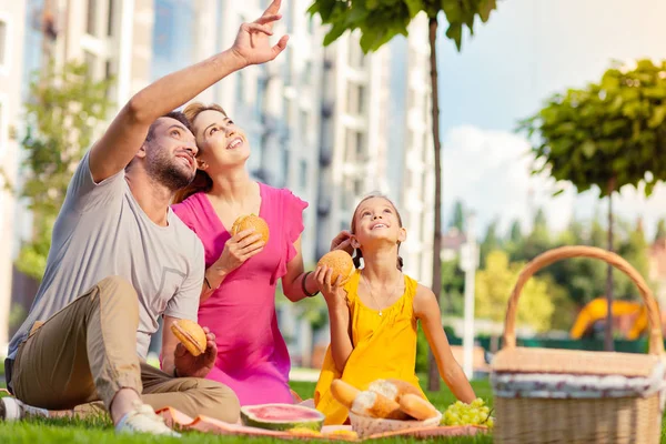 Nice happy man pointing at the sky