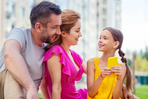 Chica alegre positiva mirando a sus padres — Foto de Stock