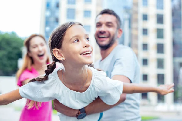Blij blij meisje speelt met haar ouders — Stockfoto