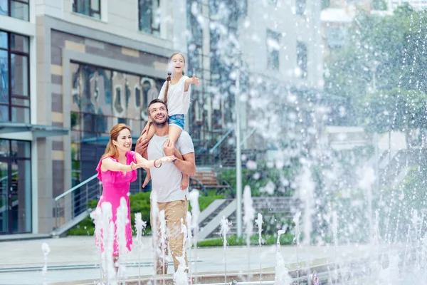 Trevlig glad familj försöker fånga vatten droppar — Stockfoto