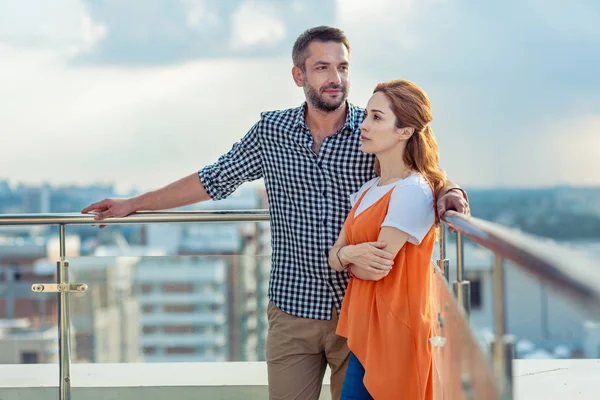 Agradable pareja agradable de pie juntos en el techo —  Fotos de Stock