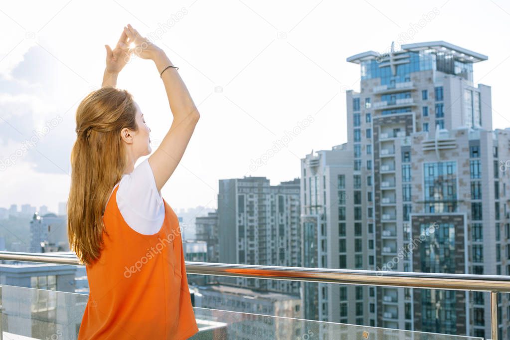 Nice joyful woman looking at the city