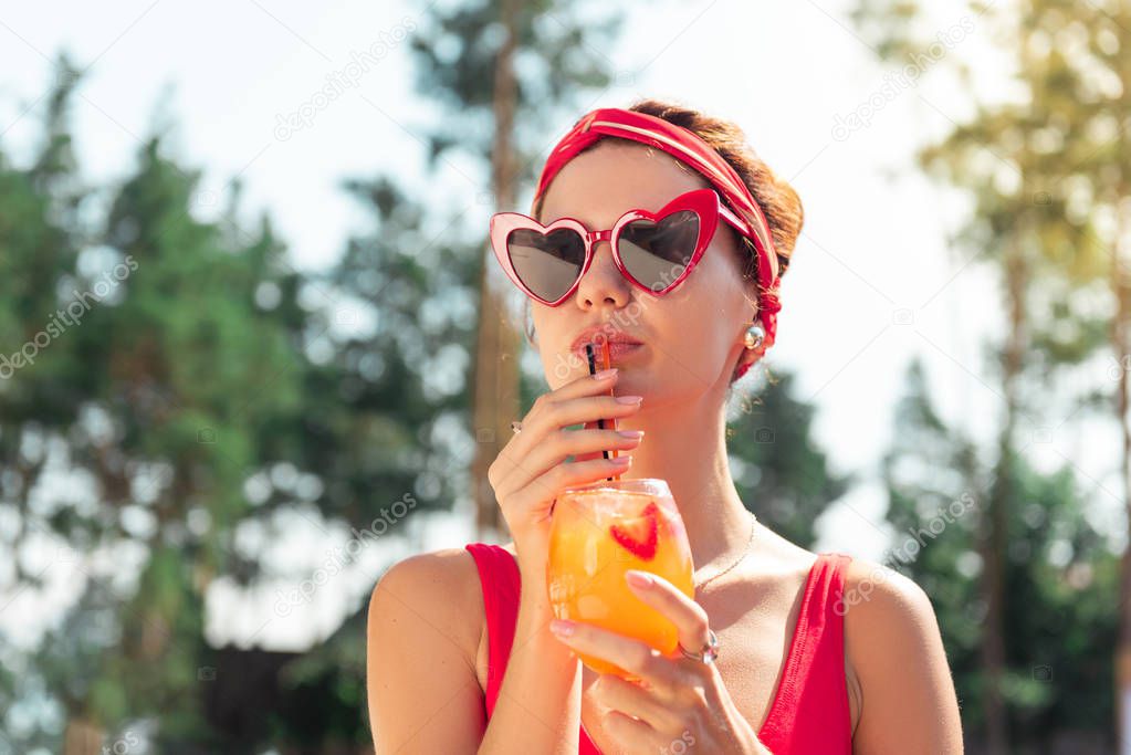 Pleasant beautiful woman enjoying her tasty drink