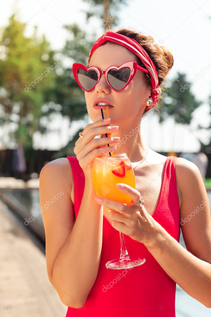 Nice attractive young woman drinking alcoholic cocktail