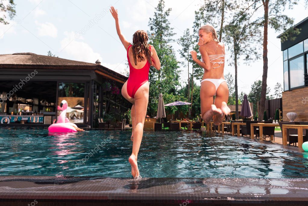 Beautiful attractive women jumping in the water