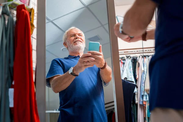 Örömteli szürke hajú férfi megcsoda a tükörképét Shopping Store — Stock Fotó