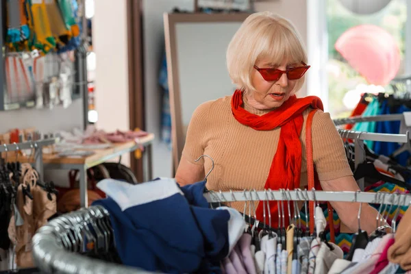 Запутавшаяся пожилая женщина наслаждается покупками на выходных — стоковое фото
