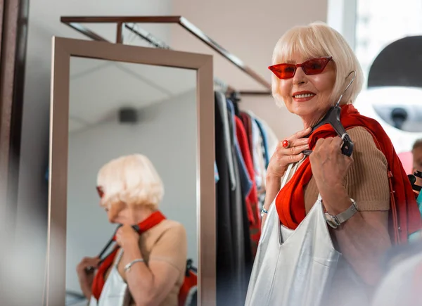 Spokojená starší žena, která drží svůj nákup blízko hrudi — Stock fotografie
