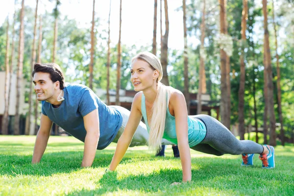 Delighted nice couple doing push ups together — Stock Photo, Image