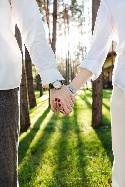 Hände eines netten, positiven Paares zusammengehalten — Stockfoto