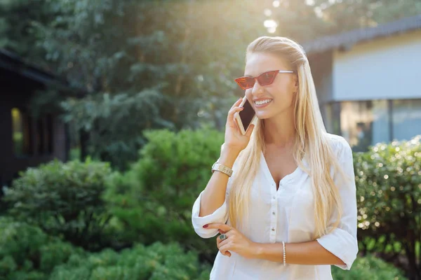 Mujer alegre agradable poniendo el teléfono a su oído — Foto de Stock