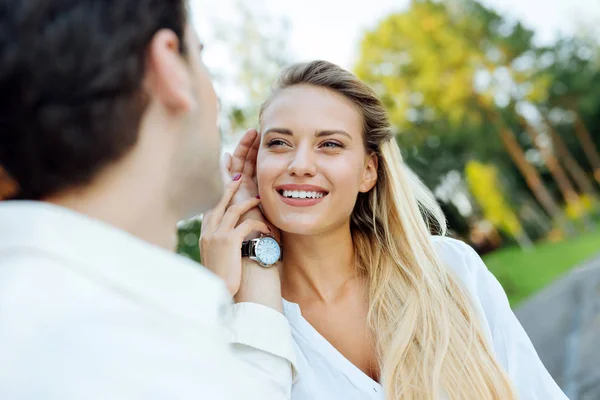 Netter junger Mann, der seine Frau an die Wange fasst — Stockfoto