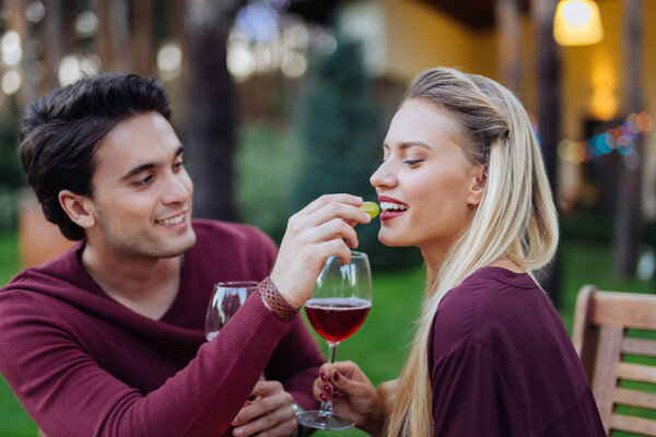 Красивая молодая женщина ест из рук своих парней
