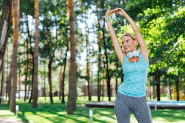 Neşeli genç kadın parkta tek başına egzersiz