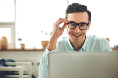 Dizüstü bilgisayar ekranına bakarak çok mutlu neşeli adam