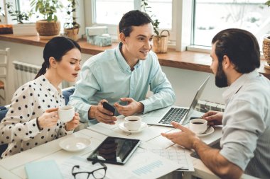 Pozitif güzel genç adam onun smartphone holding