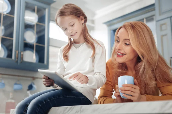 Encantadora persona femenina agradable mirando a la tableta — Foto de Stock