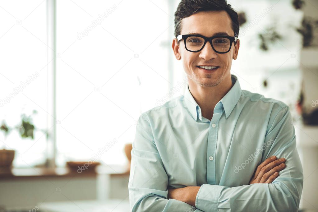 Positive smart man looking at you with delight