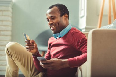 Mutlu afro Amerikalı adam kartı numarası girme