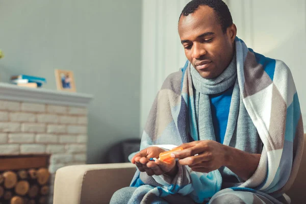 Hombre afroamericano adulto enfocado contando píldoras — Foto de Stock