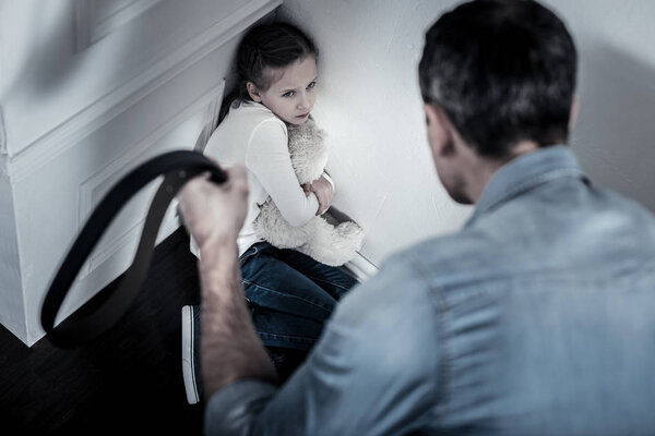 Беззащитный ребенок, сидящий на полу
