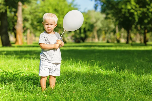 Lindo niño sosteniendo un globo en la mano — Foto de Stock