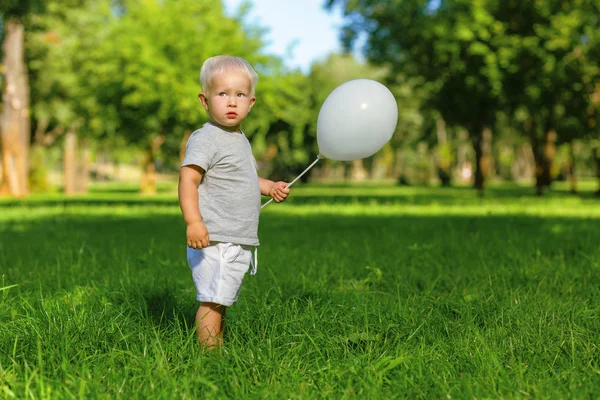 Προσεκτικός αγόρι κρατώντας ένα μπαλόνι στο χέρι — Φωτογραφία Αρχείου