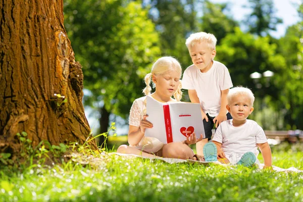 Niños atentos leyendo un libro en el parque — Foto de Stock