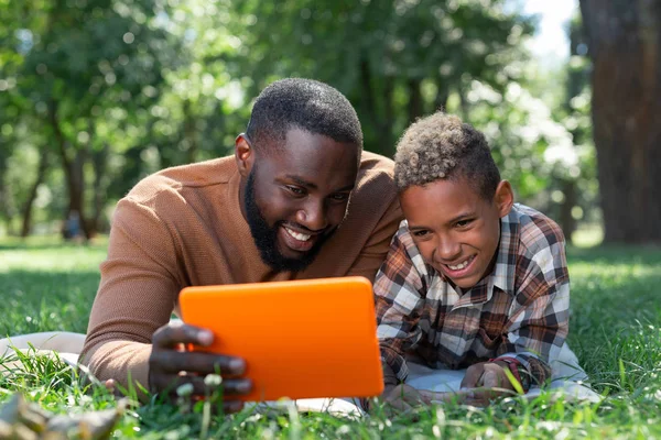 Positieve blij vader en zoon kijken naar de Tablet PC-scherm — Stockfoto