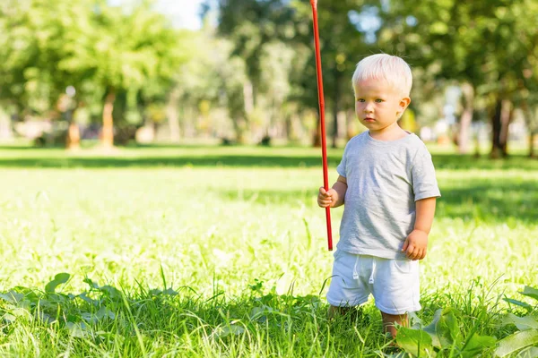 Céltudatos kis gyerek a kertben játszik — Stock Fotó