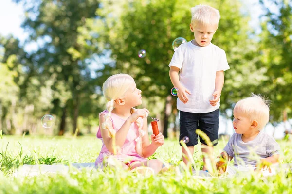 Niños emocionados jugando todos juntos en el parque —  Fotos de Stock