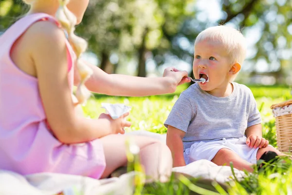 Cute kid being fed by his older sister — Stock Photo, Image