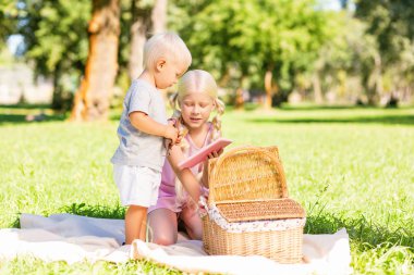 Güzel kız küçük erkek çocuk için bir dizüstü bilgisayar gösterilen