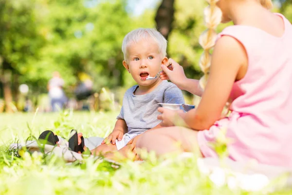 Pequeño niño siendo alimentado por una hermana — Foto de Stock