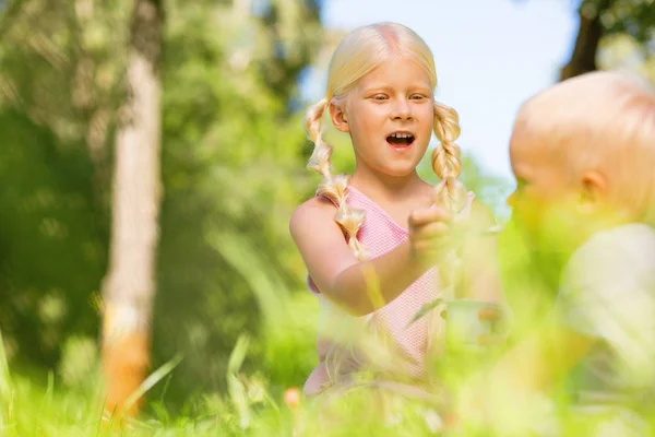 Jolie fille nourrissant un petit enfant dans le parc — Photo