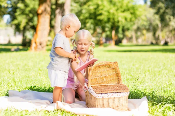 Chica bonita mostrando un cuaderno a un niño pequeño — Foto de Stock