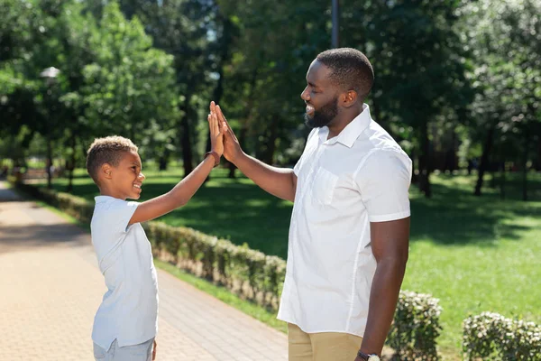 Nice happy boy giving high five to his dad — Stock Photo, Image