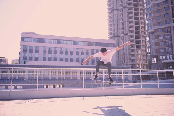 Sporty male person jumping on his skateboard