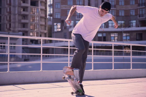 Koncentrerad eleganta mannen hoppa på sin skateboard — Stockfoto